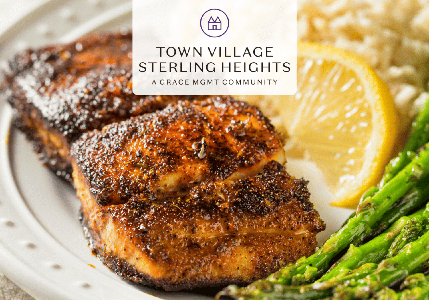 Herb-crusted grilled chicken with a lemon wedge and asparagus on a plate, Town Village Sterling Heights logo overlay.