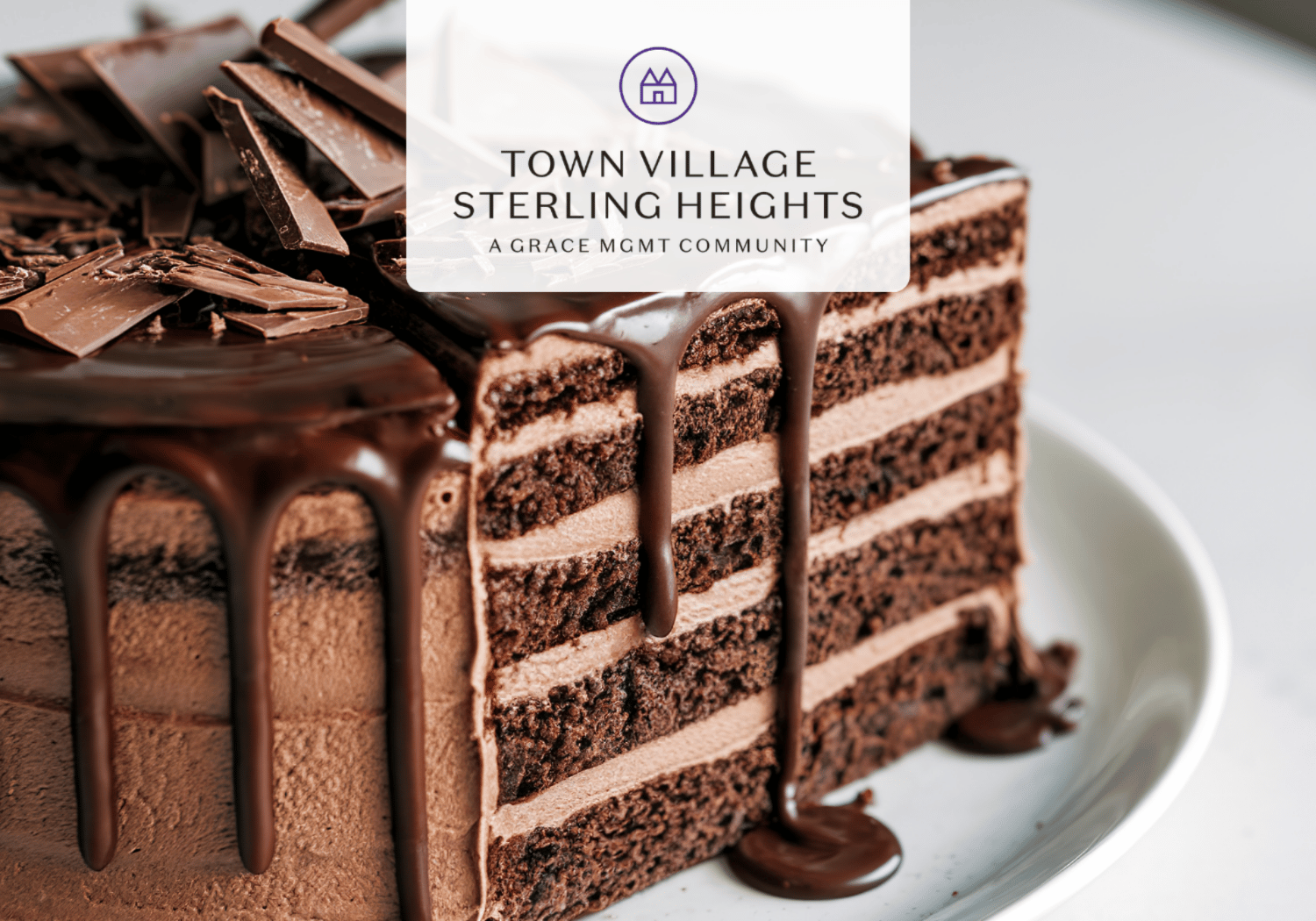 Chocolate layered cake with glossy ganache drizzle and chocolate shards, overlaid with the Town Village Sterling Heights logo and text.